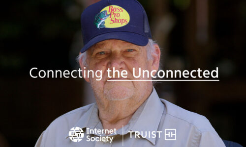 A man in a blue hat looks at the camera. Text reads: Connecting the Unconnected.