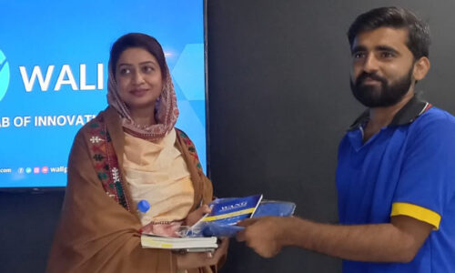 A man and a woman stand together and hold books.